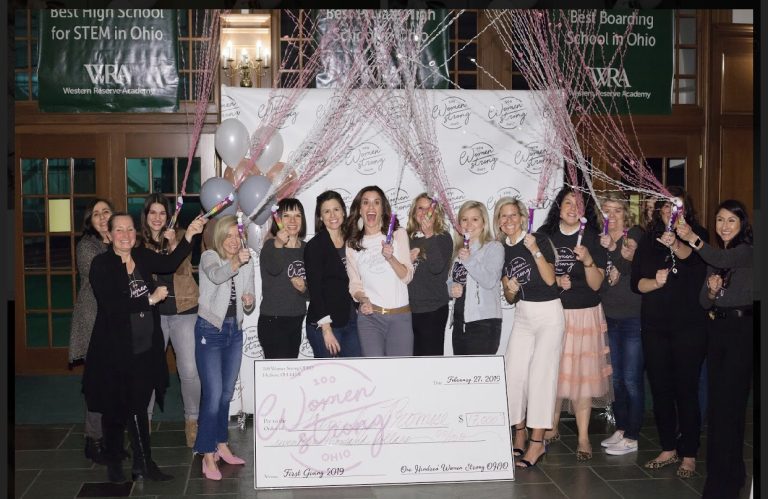 Family Promise nonprofit recipient winners of grant, with check and popping confetti cannons