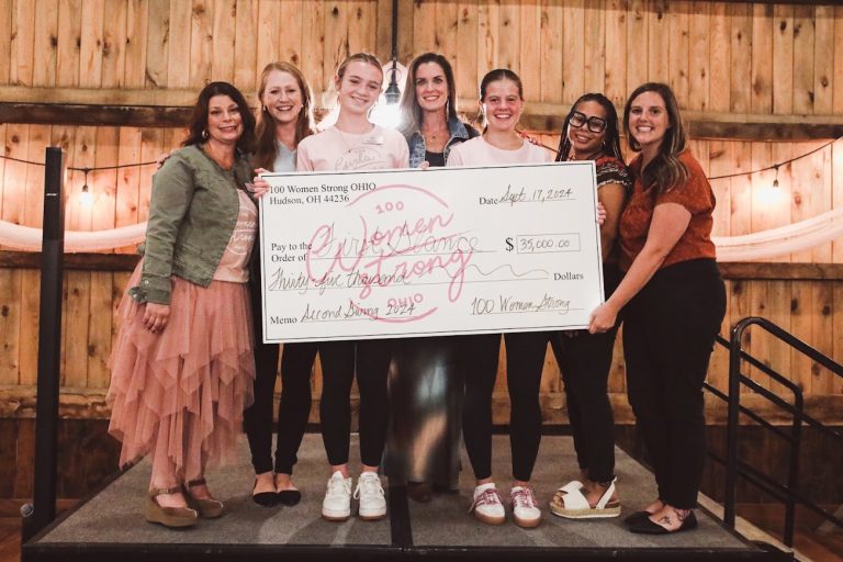 First Glance recipients holding large check with MaryJo and Jenn