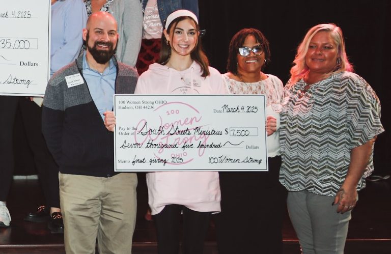 South Street Ministries group members smiling holding check from 100 Women Strong